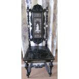 An ebonised hall chair solid seat with inlaid Renaissance figure to splat