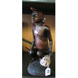 A carved kneeling Masai Warrior with spear and leather pouch approximately 14" high