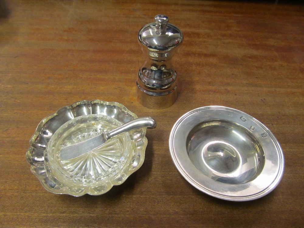 A silver pepper mill, dish, butter dish with glass liner and a knife