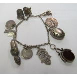 A silver charm bracelet and charms including coins and fob