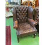 A similar chair upholstered in brown leather