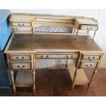 A cream painted ladies writing desk with drawers and pierced gallery to top over five drawers on