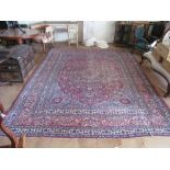 A Persian rug with central floral medallion surrounded by floral borders