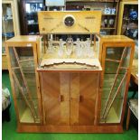 An Art Deco walnut cocktail/display cabinet (faded) with some fitted glassware