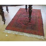 A Persian rug with red, black and orange geometric design