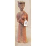 A Chinese terracotta figure holding a vase (restored)