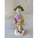 A 19th Century porcelain nodding head figure with leaf hat (slight chip)