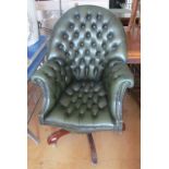 A green leather button upholstered arch top desk chair