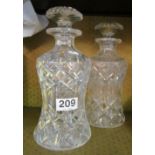 A pair of cut glass decanters with waisted bodies