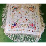 An Oriental shawl embroidered brightly coloured flowers (stained)