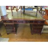 A reproduction twin pedestal desk of eight drawers with leather inset top