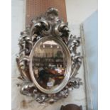 A modern silver coloured mirror leaf scroll frame