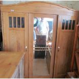 A large pine wardrobe with central mirror door