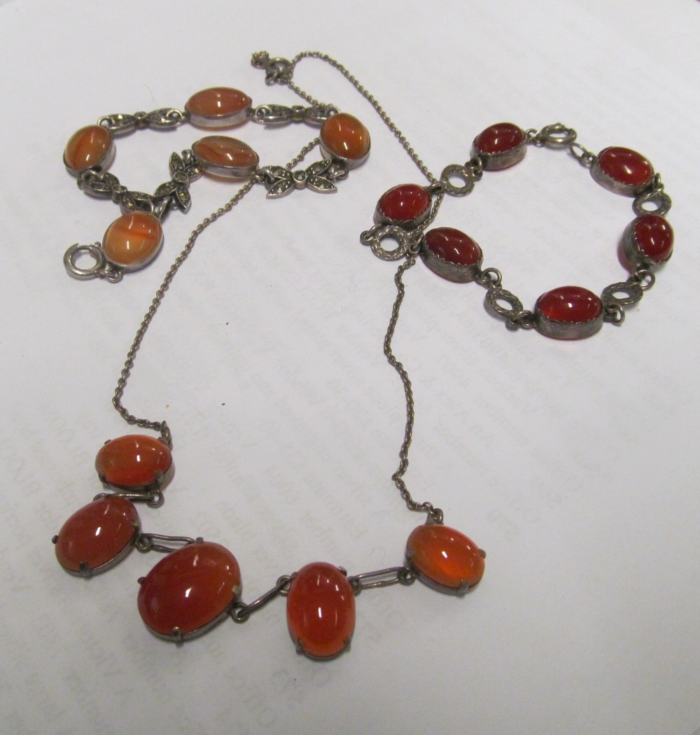 A sterling silver bracelet, orange coloured stones, another silver bracelet and another