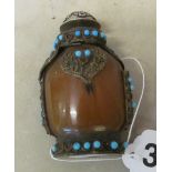 An agate Tibetan snuff bottle with turquoise and metal mounts and a silver coloured stopper