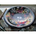 A Moorcroft dark blue glazed bowl decorated pink and blue flowers
