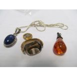 A gold coloured fob, amber style pendant and silver pendant with blue stone