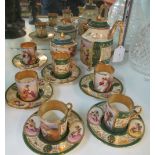 A Continental porcelain coffee set decorated ladies and cherubs with green, cream and gilt