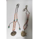 Two Eastern coral and turquoise necklaces hung with white metal pendants