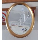 An oval white bevelled mirror and a gilt oval mirror
