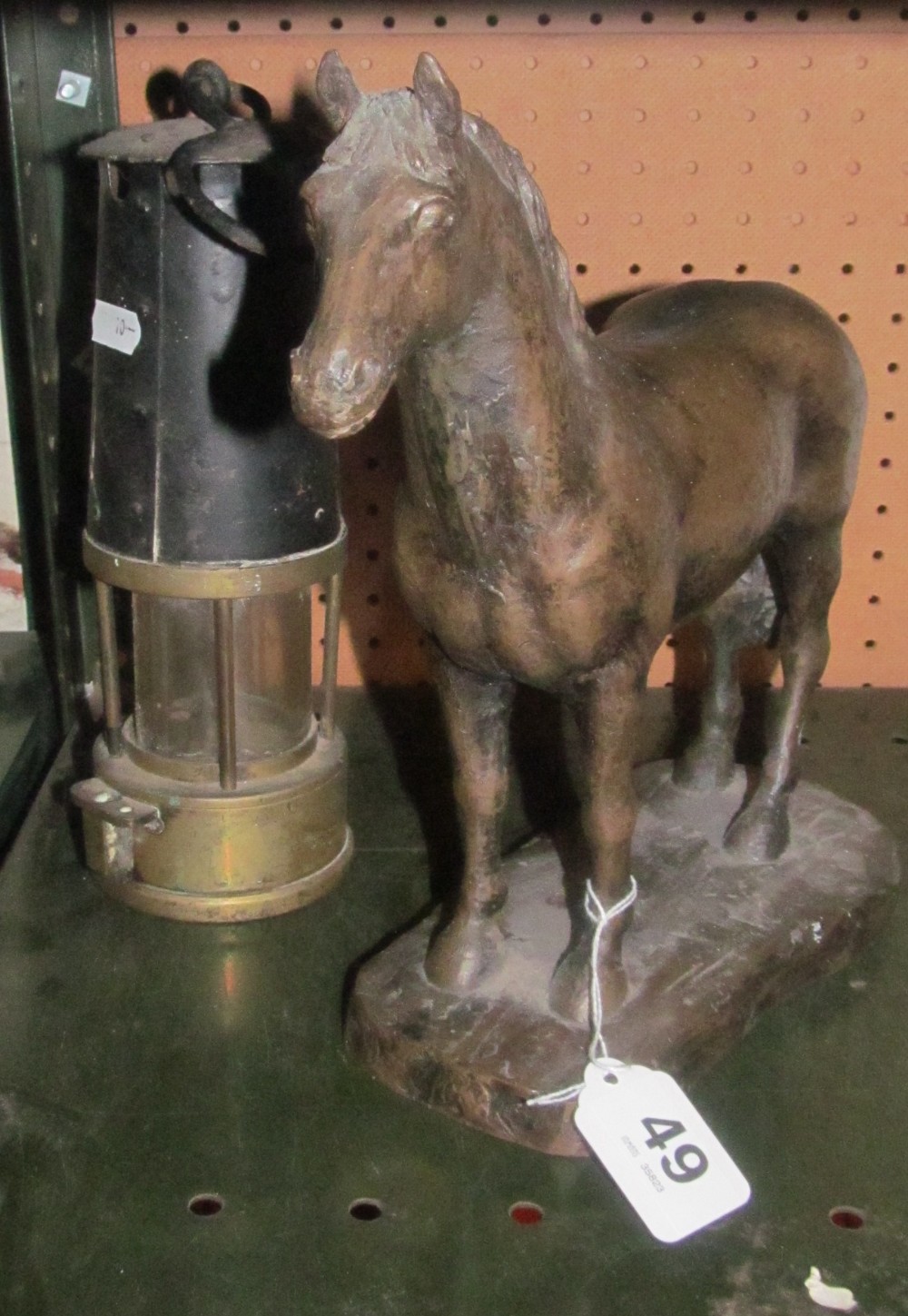 A Miner's lamp and bronze effect horse