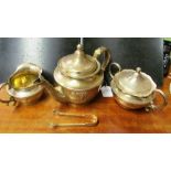 A Shreve & Co. Sterling silver Arts & Crafts style three piece teaset and matching sugar tongs (