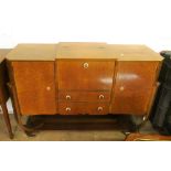 A 1940's walnut and birds eye maple dining table, four chairs and a sideboard with central