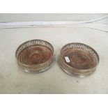 A pair of silver pierced edge wine bottle coasters