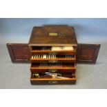A Silver Plated Canteen of Cutlery housed within a Mahogany Canteen Cabinet of four drawers with