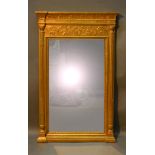 A Gilt Framed Wall Mirror of Rectangular Form with a frieze decorated in relief above a