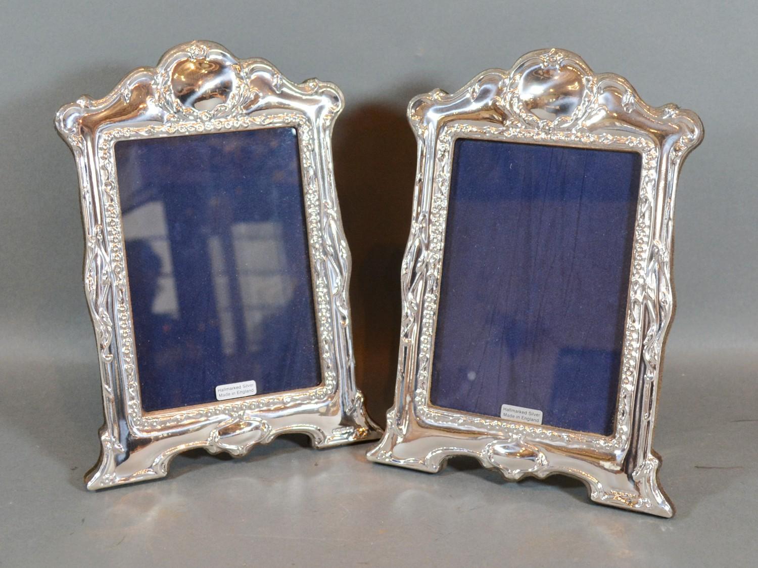 A Pair of Sterling Silver Photograph Frames, each of shaped and embossed form 21.5cm by 15cm