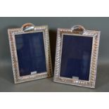 A Pair of Sterling Silver rectangular Photograph Frames with embossed decoration 20cm by 13.5cm