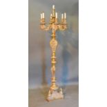 A Large Gilded Floor Standing Candelabrum with six rams head branches above a shaped column and