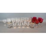 Five Cranberry Glass Pedestal Glasses together with a small set of glasses, four tapered glasses and