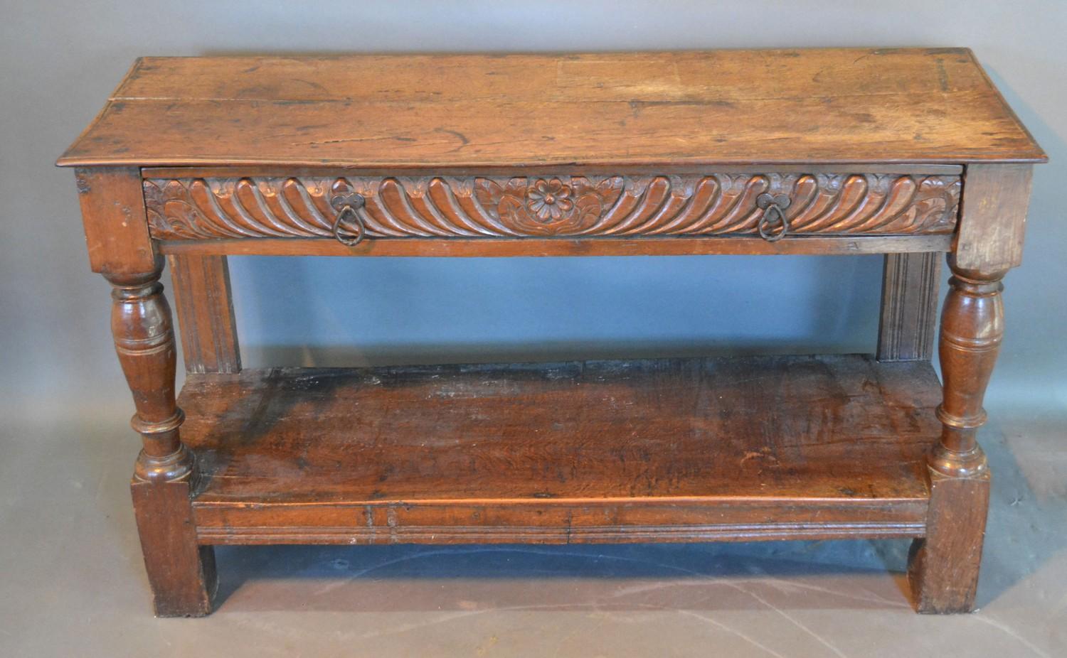 A George III Oak Side Table, the plank top above a carved frieze drawer with iron handles above an
