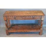 A George III Oak Side Table, the plank top above a carved frieze drawer with iron handles above an