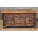 An 18th Century Oak Coffer, the hinged top above a three carved panel front flanked by stiles, 119