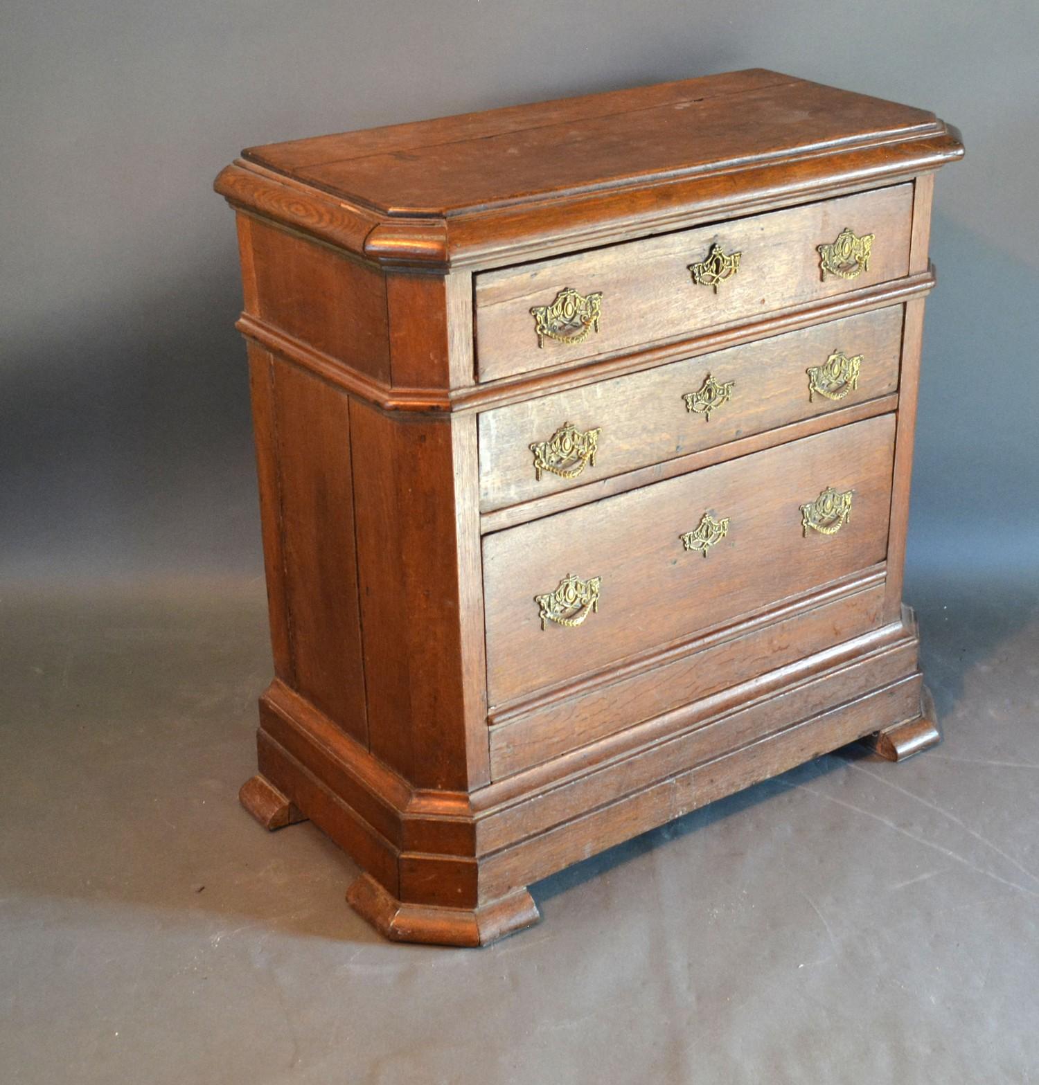 A 19th Century Continental Oak Small Chest, the moulded top above three long drawers with brass