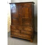 A George III Oak Bacon Cupboard, the moulded cornice above two panelled doors enclosing a hanging