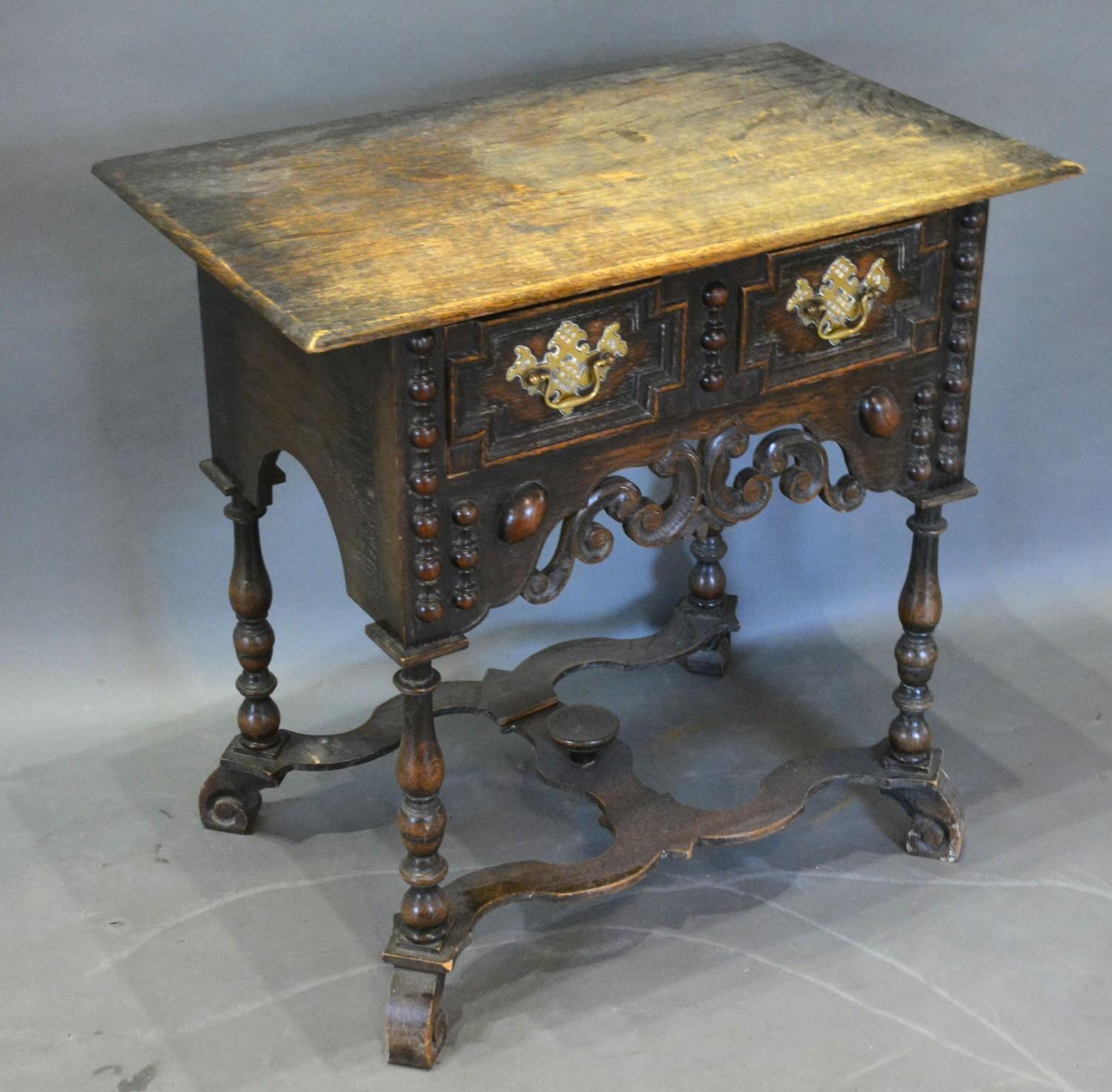 A Jacobean Style Oak Low Boy, the geometric moulded and pierced front with a frieze drawer and brass