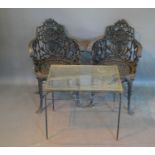 A Pair of Patinated Garden Seats together with a similar glass top table