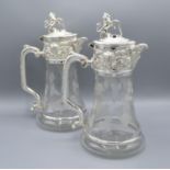 A Pair of Cut Glass and Silver Plated Claret Jugs each with a hinged cover and lion cresting and