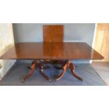 A Regency Mahogany Dining Table, the reeded top above twin end turned supports with reeded