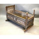 A George III Oak Cradle with Arcadian Carved Panels 104 cms long