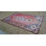 A North West Persian Woollen Carpet with three central medallions with an all over design upon a