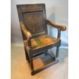 A George III Oak Wainscot Chair, the carved back above a panel seat with scroll arms raised upon