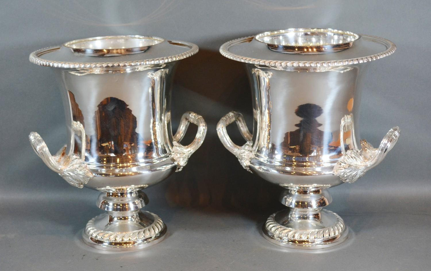 A Pair of Silver Plated Two Handled Wine Coolers with inner liners upon circular pedestal bases 27cm