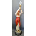 A Floor Standing Lamp Standard in the form of an Egyptian Figure all upon a black circular plinth,