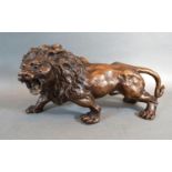 A Patinated Bronze Model in the form of a Lion, 33 cms long