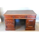 A 20th Century Twin Pedestal Desk, the leather inset top above six drawers and a cupboard door
